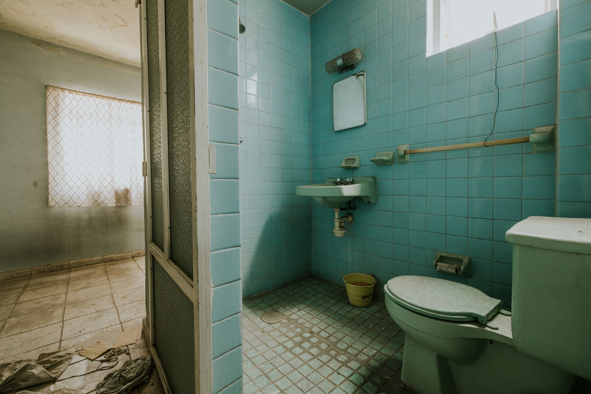 Il bagno prima della ristrutturazione, con piastrelle e sanitari da sostituire
