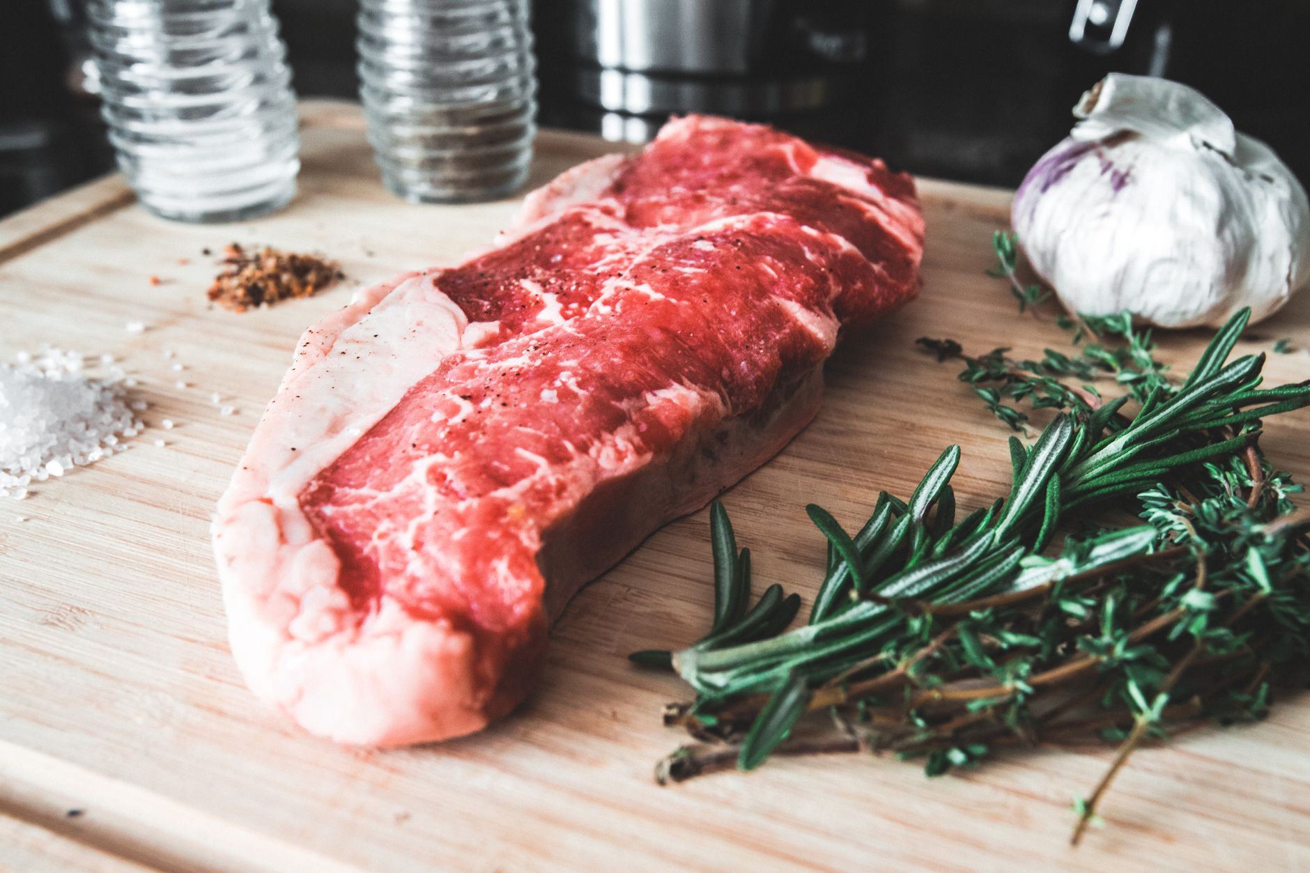 Costata di carne cruda su tagliere con rosmarino