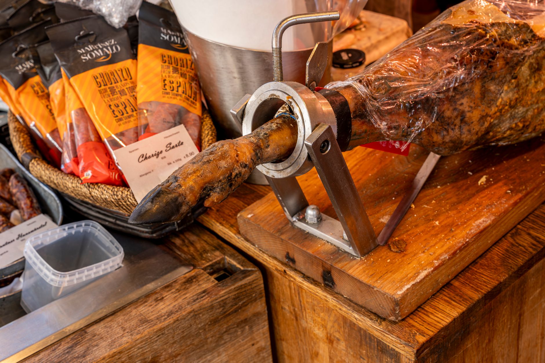 Interno della bottega con i salumi appesi e il bancone in legno