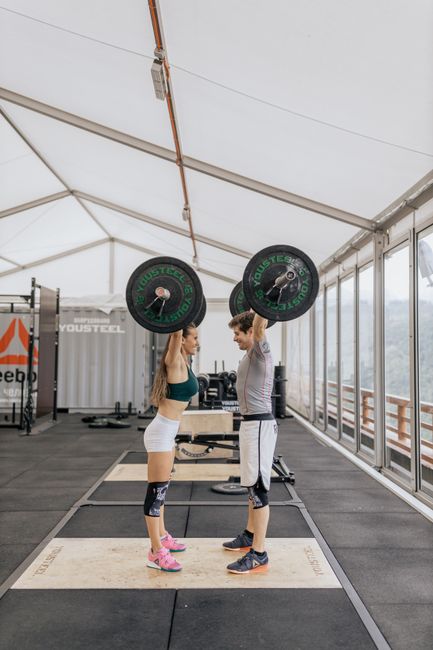 Personal trainer che segue un cliente in sala pesi