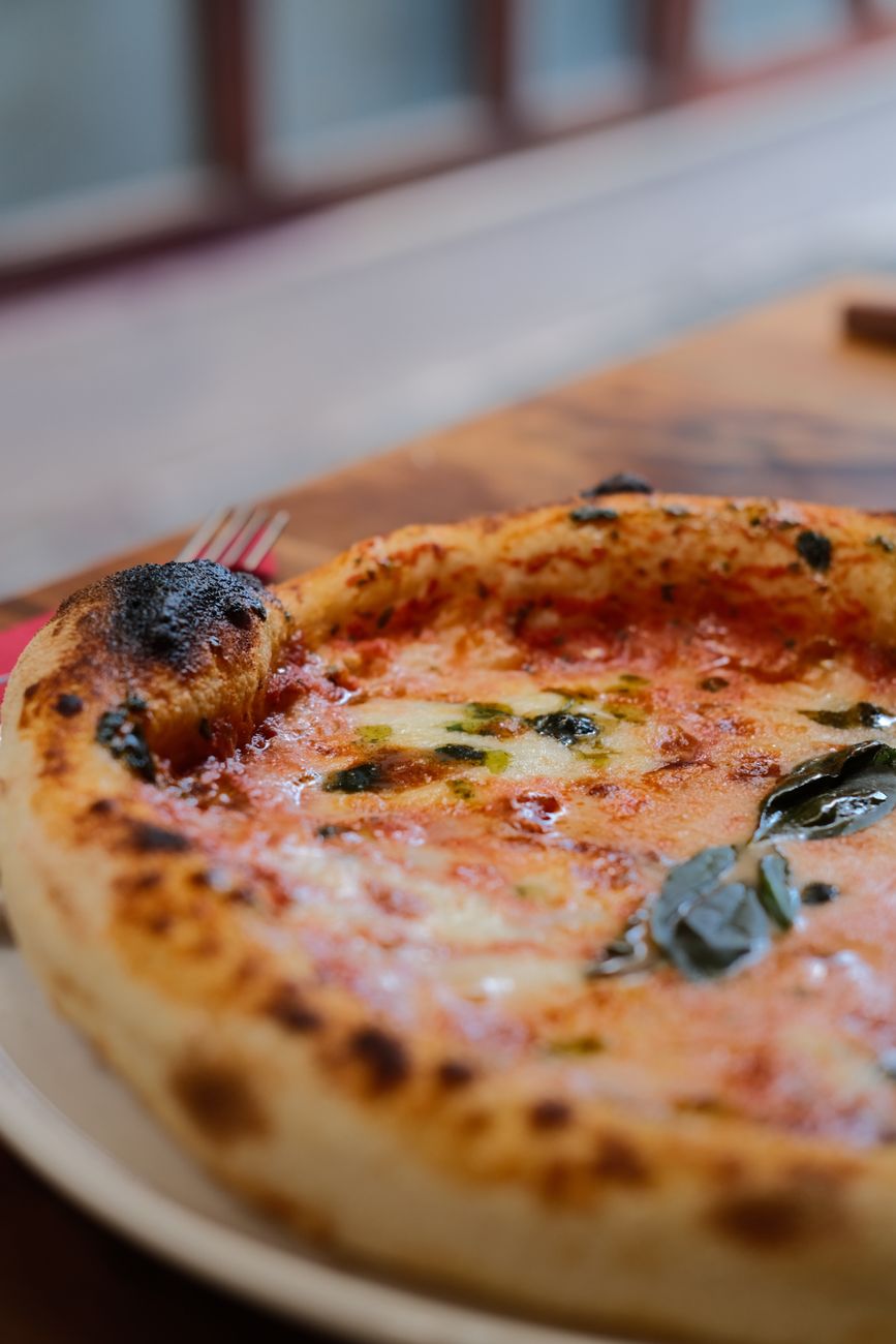 Il cornicione di una pizza appena sfornata, con le bolle bruciate della cottura